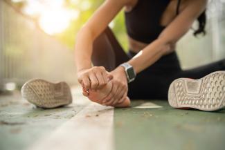 Woman runner sitting down with foot pain
