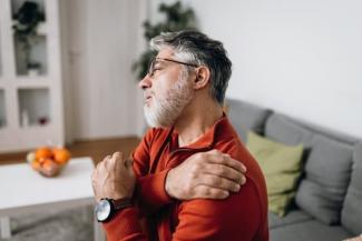 older man holding painful shoulder
